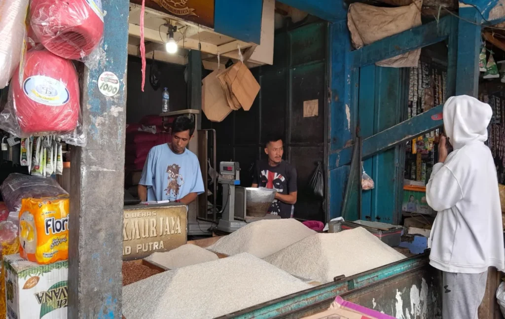 Pedagang beras, Iman saat sedang melayani pembeli di lapak daganganya di pasar Ciawitali.(Ale/Radar Garut)