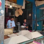 Pedagang beras, Iman saat sedang melayani pembeli di lapak daganganya di pasar Ciawitali.(Ale/Radar Garut)