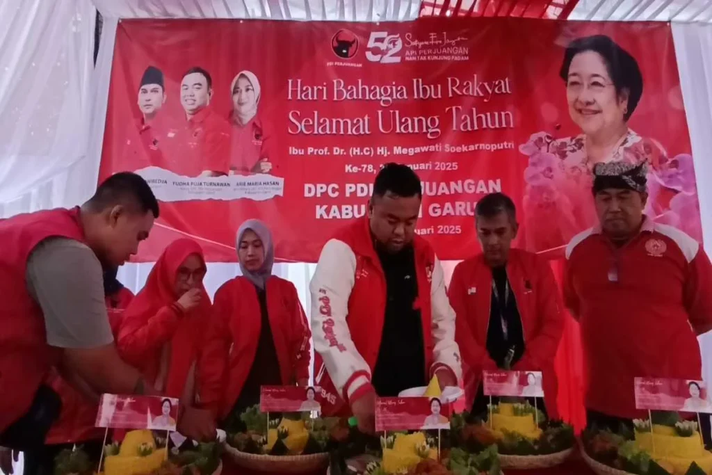 Yudha Puja Turnawan memotong tumpeng pertama untuk diberikan kepada kalangan pemulung dalam acara peringatan H