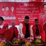 Yudha Puja Turnawan memotong tumpeng pertama untuk diberikan kepada kalangan pemulung dalam acara peringatan H