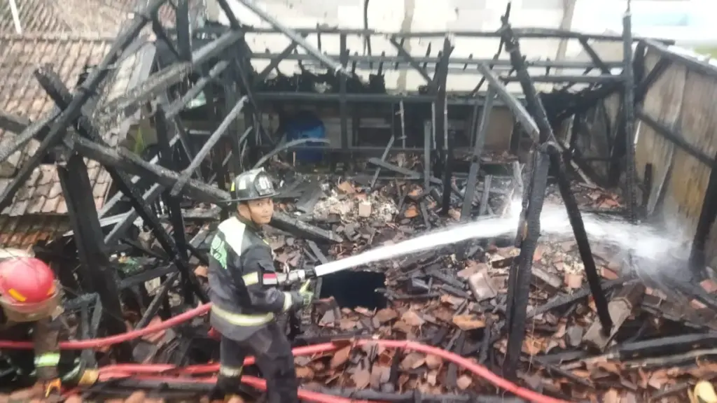 Petugas Damkar Garut saat melakukan proses pemadaman api di sebuah rumah semi permanen yang terbakar