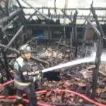Petugas Damkar Garut saat melakukan proses pemadaman api di sebuah rumah semi permanen yang terbakar