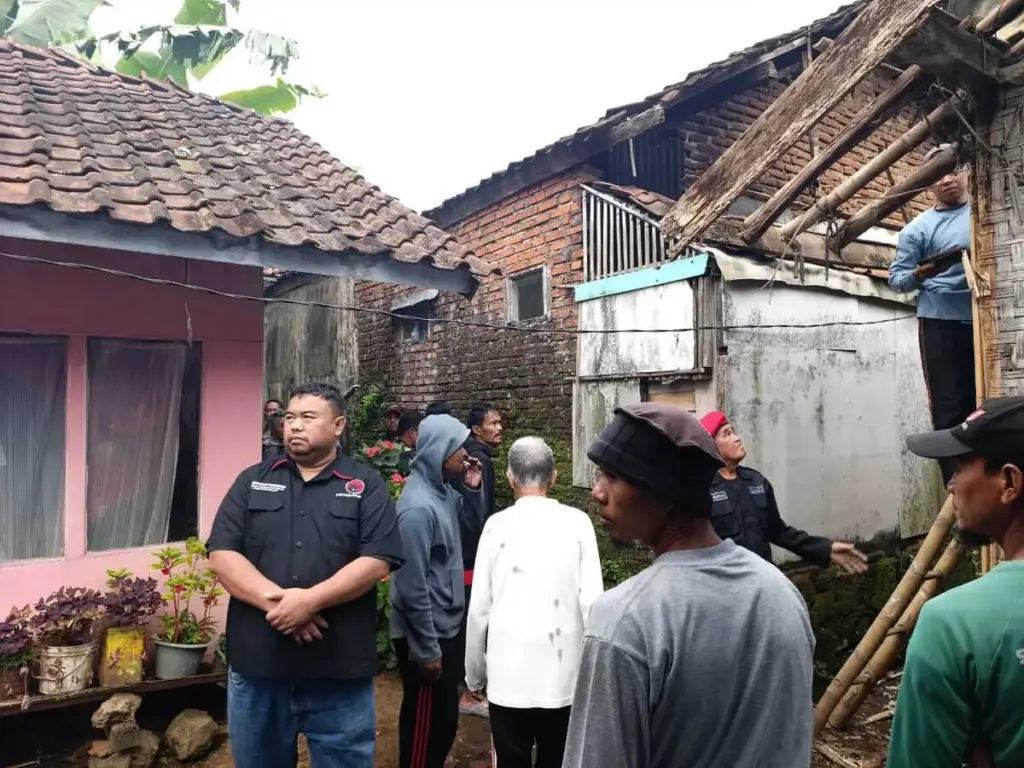 Yudha Puja Turnawan di tengah warga sedang membongkar rumah emak Eja