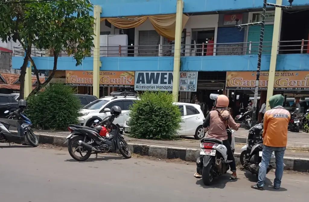 Petugas parkir resmi memakai seragam khusus motif batik oranye dilengkapi name tag. (Foto: Ale/Radar Garut)
