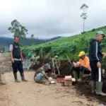 Bhabinkamtibmas Polsek Pasirwangi bersama warga membersihkan saluran air. (Istimewa)