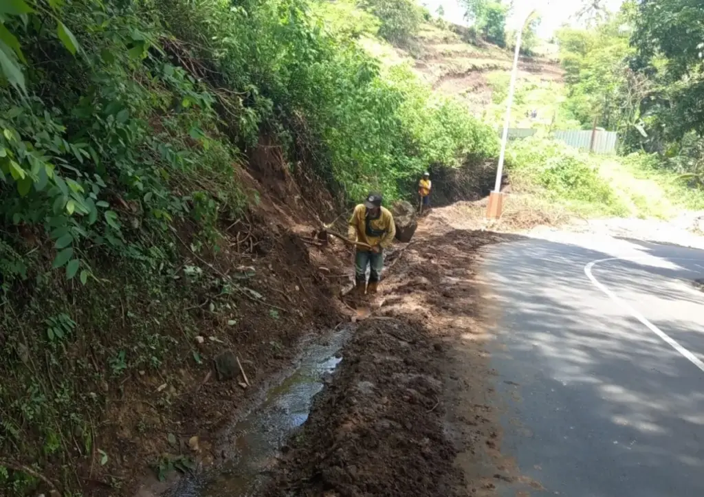 Pegawai Dinas PUPR Jabar mengangkat longsoran tanah yang menimbun drainase. (Pepen Apendi)