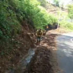 Pegawai Dinas PUPR Jabar mengangkat longsoran tanah yang menimbun drainase. (Pepen Apendi)