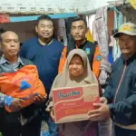 Yudha Puja Turnawan bersama petugas BPBD memberikan bantuan kepada emak Jaja
