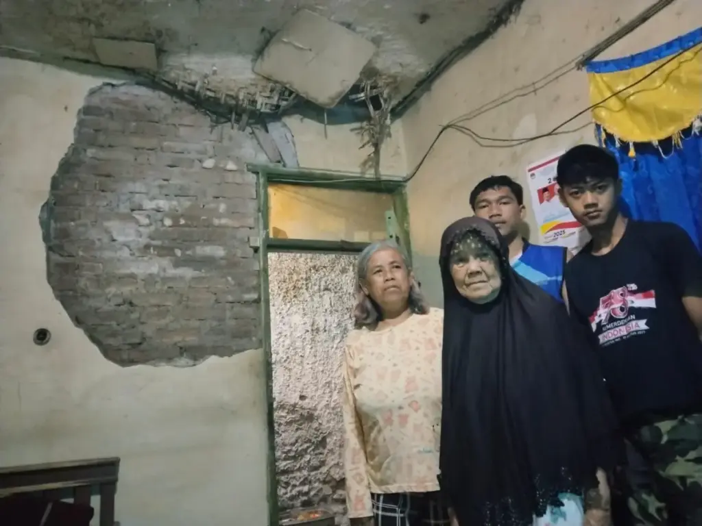 Tinggal di Rumah Hampir Roboh, Emak Iyam Menanti Bantuan Pemerintah Emak Iyam dan keluarga yang tinggal di rumah yang hampir roboh