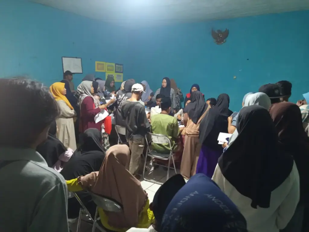 Ratusan KPM antri mengambil bantuan beras dan minyak goreng di ruang rapat Desa Cibiuk Kaler, Kecamatan Cibiuk